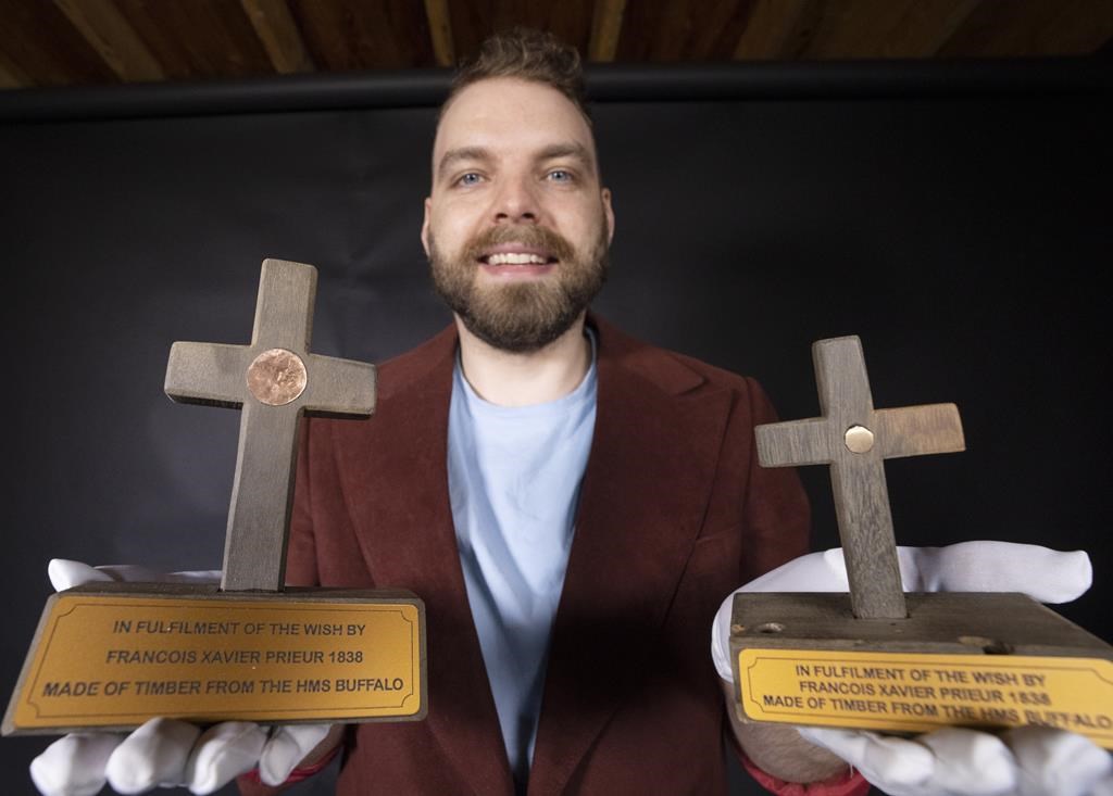 Sam Pineault holds a pair of wooden crosses made from a shipwreck in New Zealand in his studio in St. Jean-Sur-Richelieu, Que., Friday, June 9, 2023. THE CANADIAN PRESS/Ryan Remiorz.