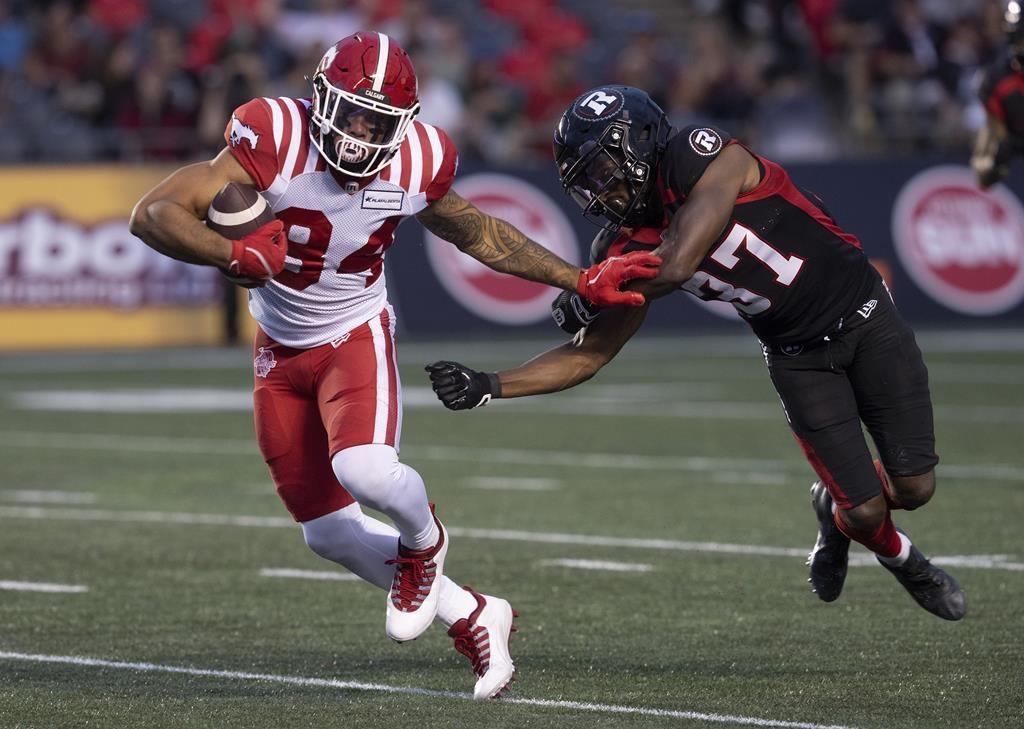Calgary Stampeders wide receiver Reggie Begelton, left, breaks free of a tackle from Ottawa Redblacks defensive back Brandin Dandridge during first half CFL action, Thursday, June 15, 2023 in Ottawa.
