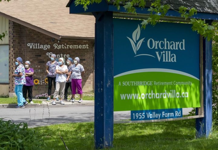 Workers watch as nursing union members show their support at the Orchard Villa Long-Term Care in Pickering, Ont. on Monday June 1, 2020.&nbsp;Ontario has used its powers to push through the redevelopment of three long-term care homes run by a company that was devastated by deaths during the pandemic.