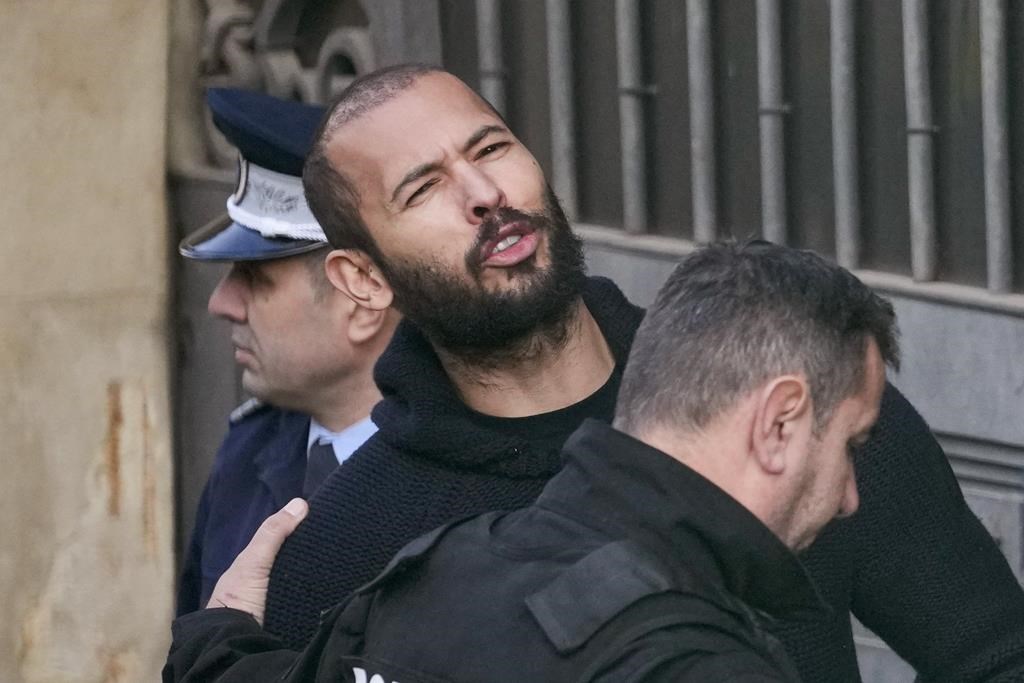 Police officers escort Andrew Tate to the Court of Appeal in Bucharest, Romania, Wednesday, Feb. 1, 2023.
