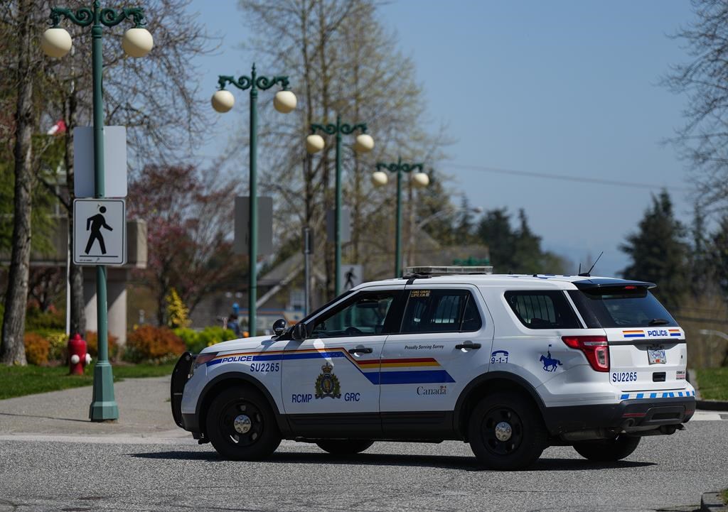 A Surrey RCMP officer drives a police vehicle in Surrey, B.C., Friday, April 28, 2023. An ethics report has found that a Surrey councillor who had family working for the RCMP breached ethics rules when he voted to halt the transition to a city police force.
