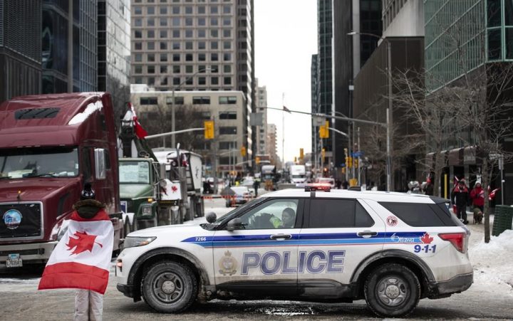An Ottawa police vehicle blocks off Kent Street in front of parked trucks as a protest against COVID-19 restrictions continues into its second week, in Ottawa on Sunday, Feb. 6, 2022. The Ottawa Police Service was flooded with 410 public complaints regarding officer conduct during the 'Freedom Convoy' demonstrations, which clogged and caused disturbances to Ottawa’s downtown core for more than three weeks. 