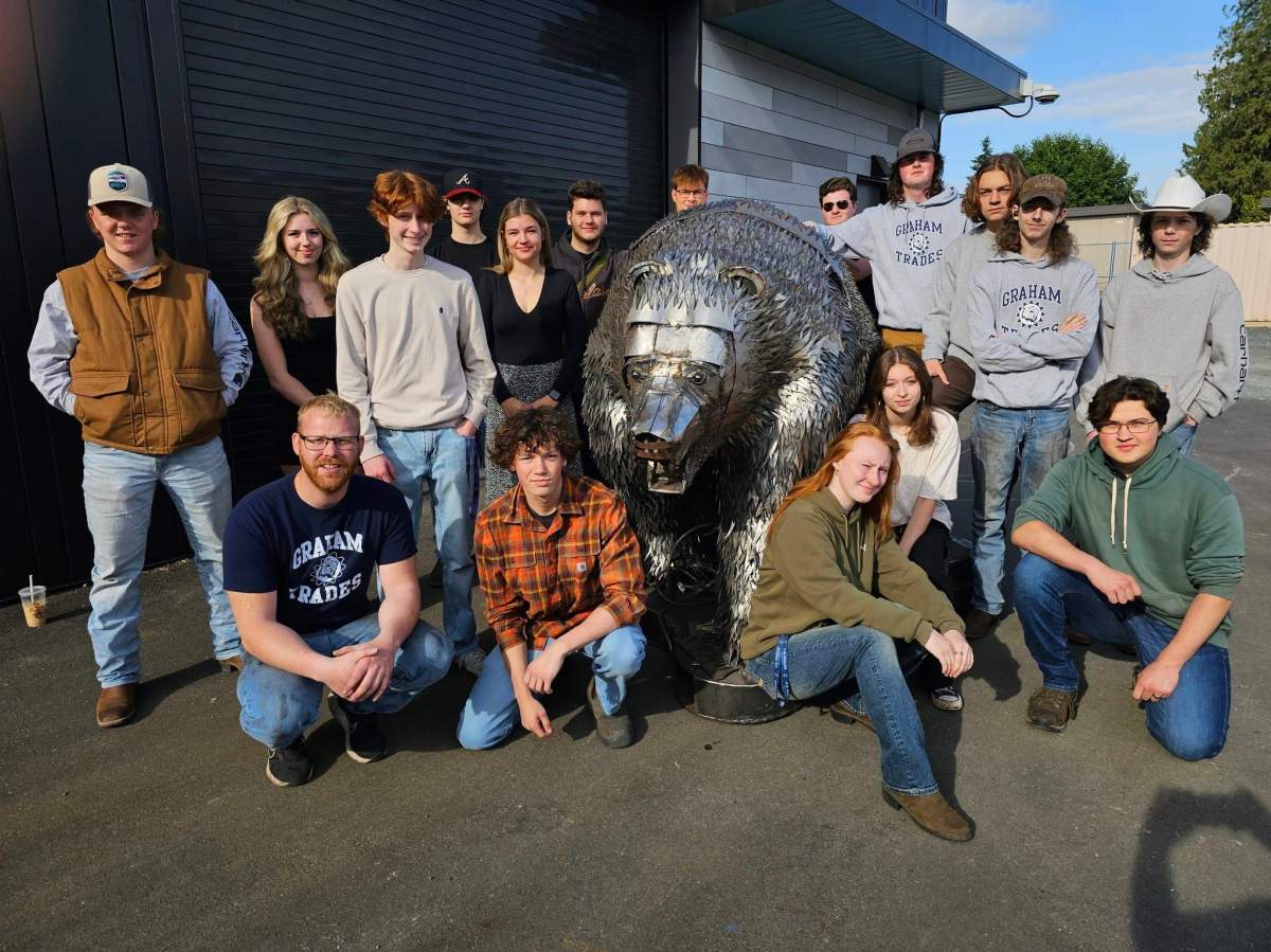 Some of the students and their teacher, Brad Bootsma, from the metal shop class with their creation.