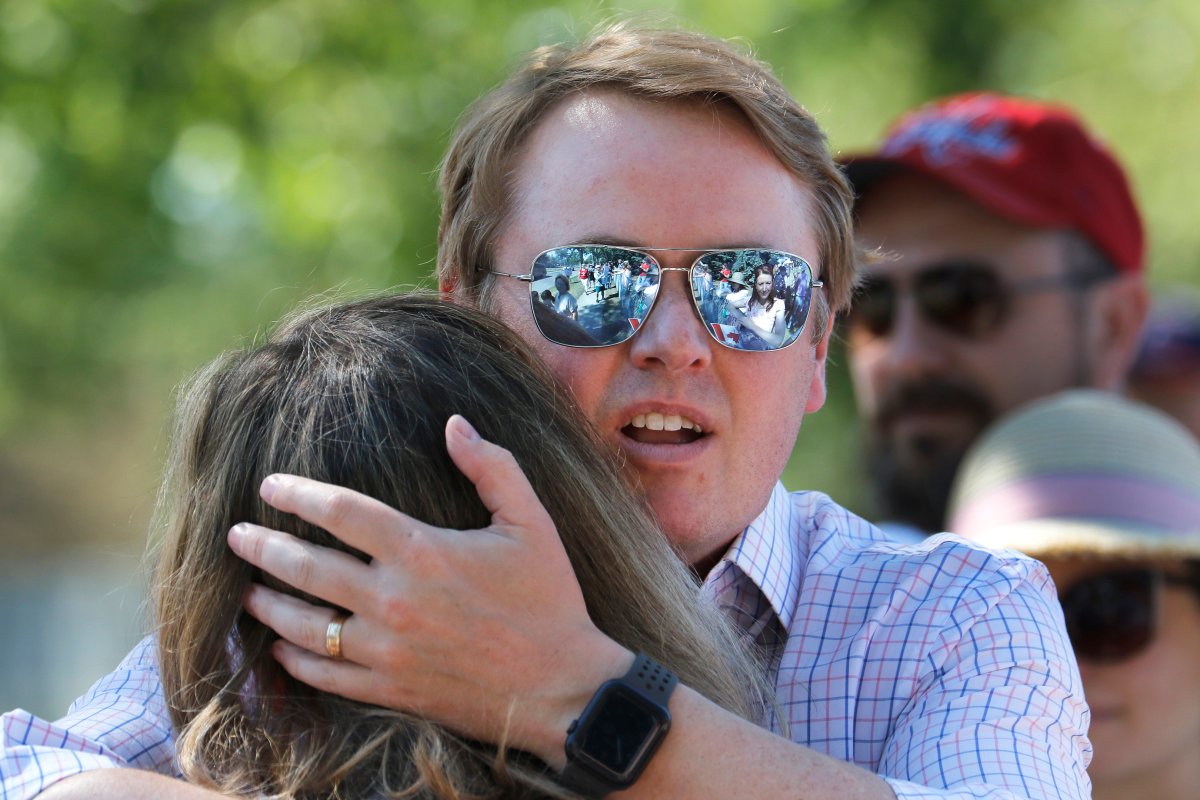 Alberta Health Minister Tyler Shandro hugs his wife Andrea after being heckled by protesters upon arrival with his family to celebrate the lifting of public health restrictions and Canada Day activities in Calgary, Alta., Thursday, July 1, 2021.