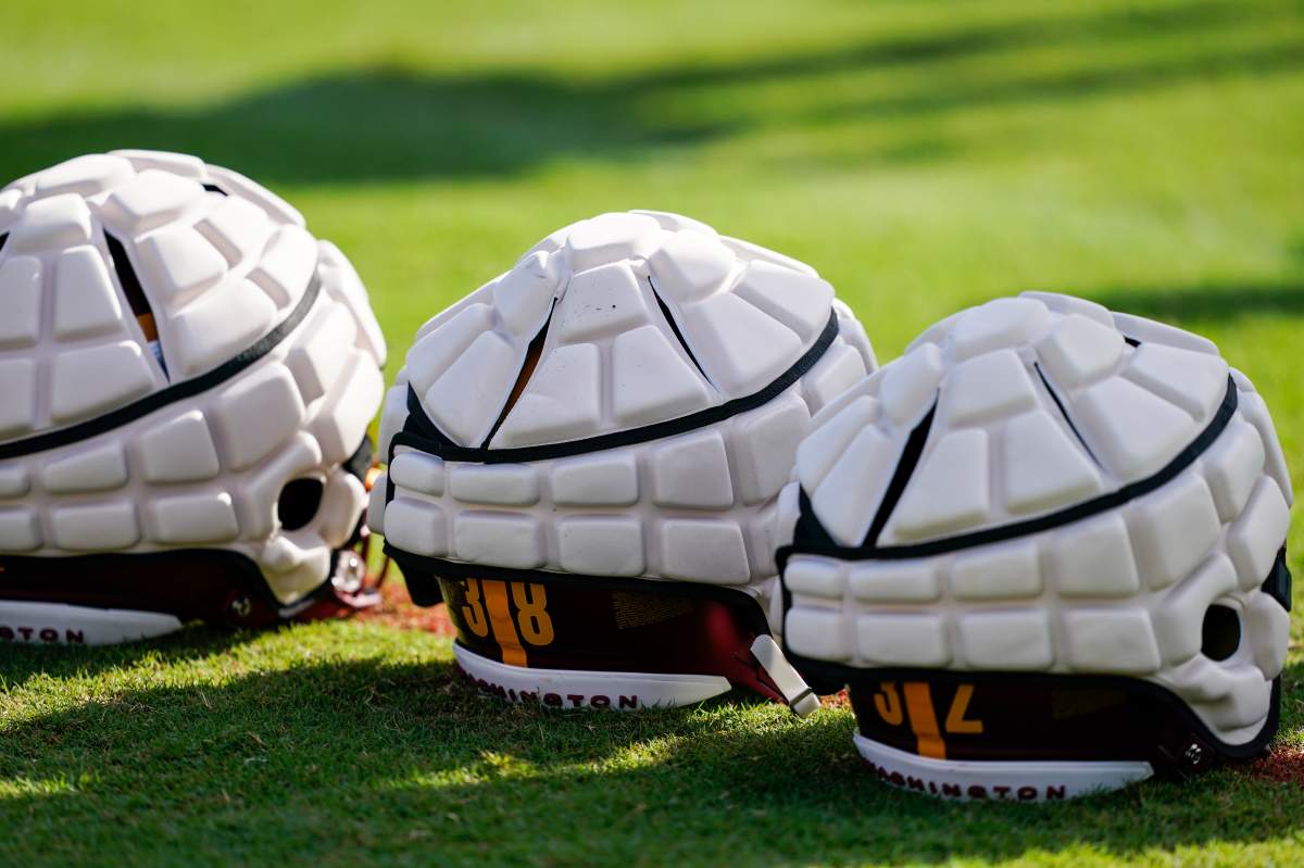 Washington Commanders helmets with Guardian Caps sit on the field during practice at the team's NFL football training facility, Saturday, July 30, 2022 in Ashburn, Va. The mushroom-like contraptions NFL players are wearing on their helmets during training camp may look strange, but they're a part of an ongoing safety experiment the league hopes will lead to a reduction in head injuries. They're called Guardian Caps, and they're now mandatory for all 32 NFL teams through the second preseason game -- the time when the league says head injuries are most prevalent.