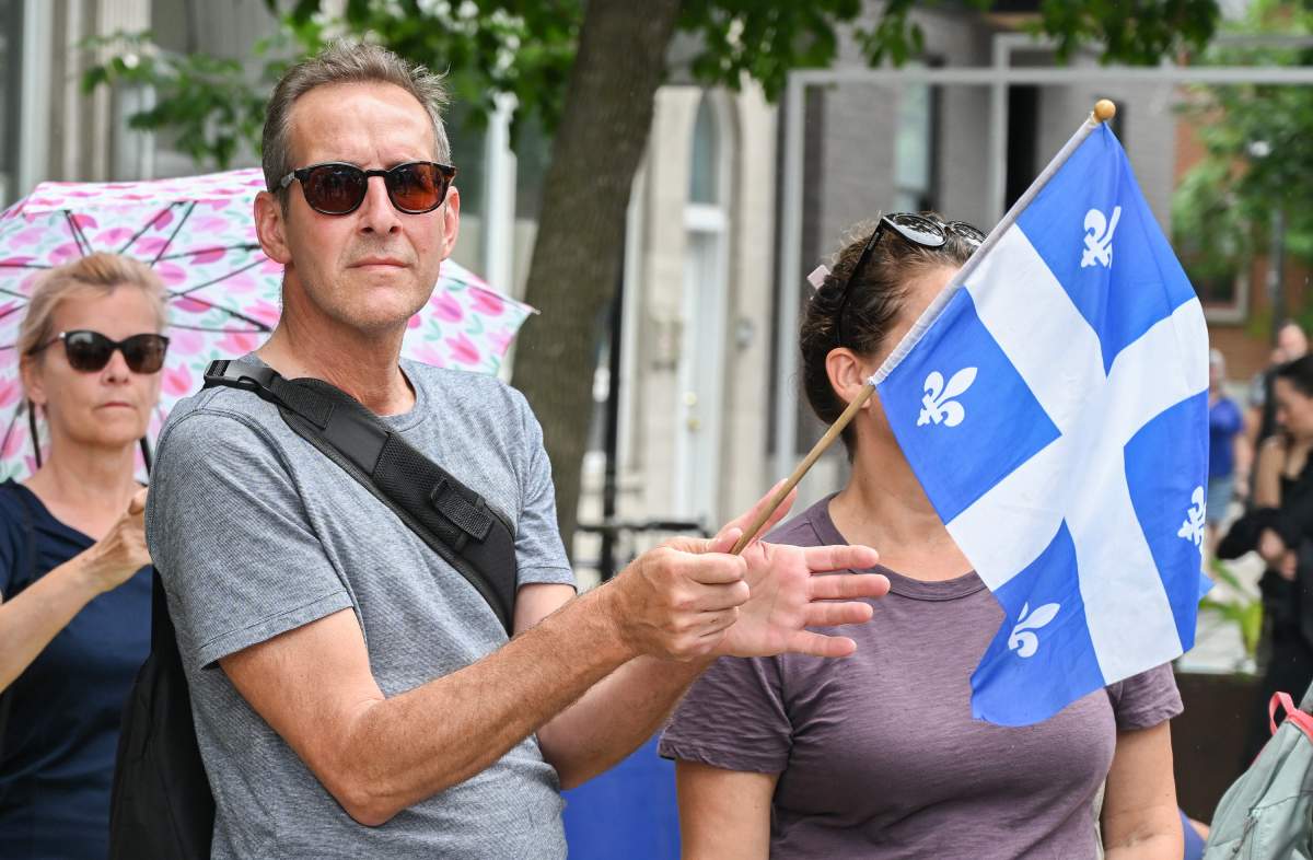 A man waves a Quebec flag on Saint-Jean-Baptiste day in Montreal, Saturday, June 24, 2023.