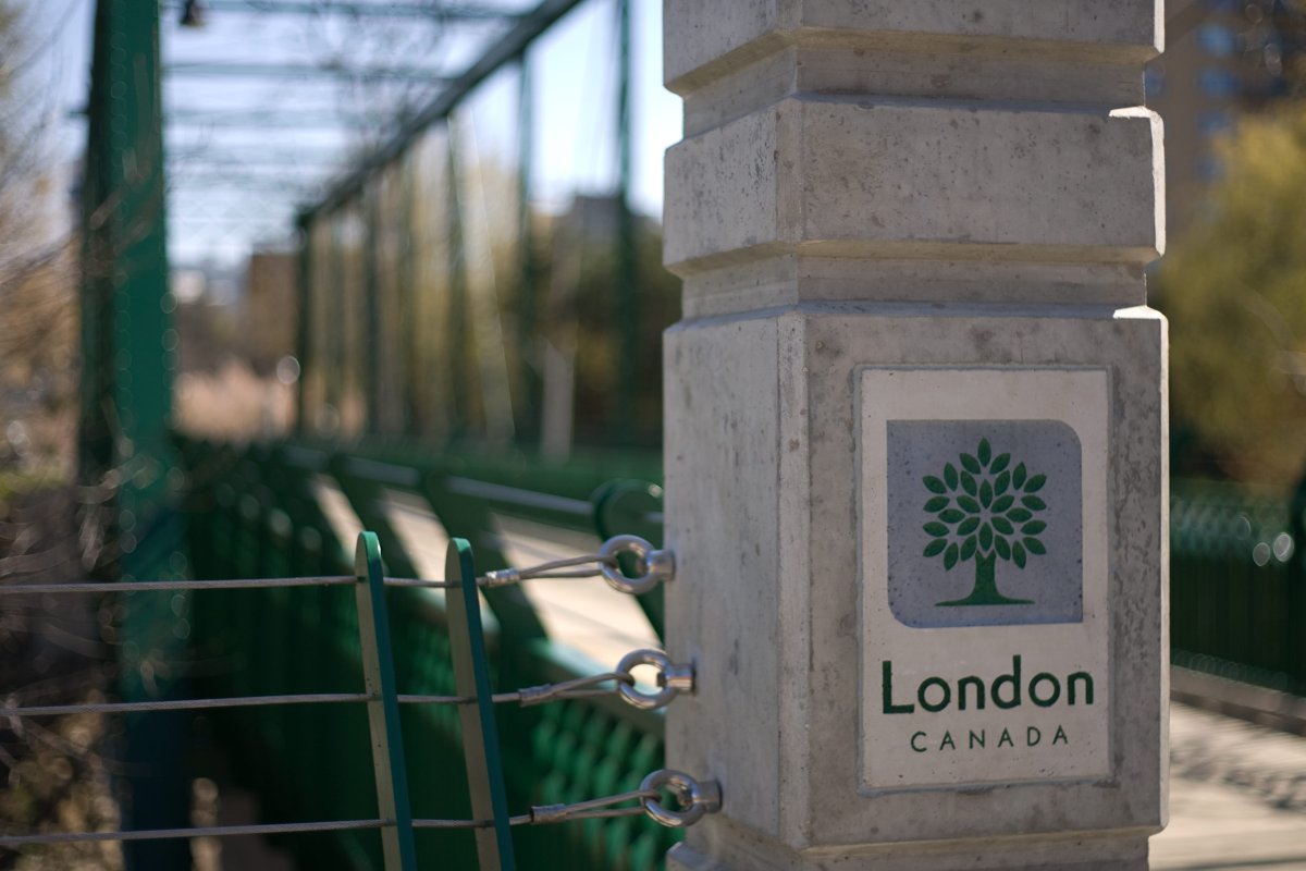 A closeup of a pillar with the City of London crest in it as part of a footbridge over the Thames River.