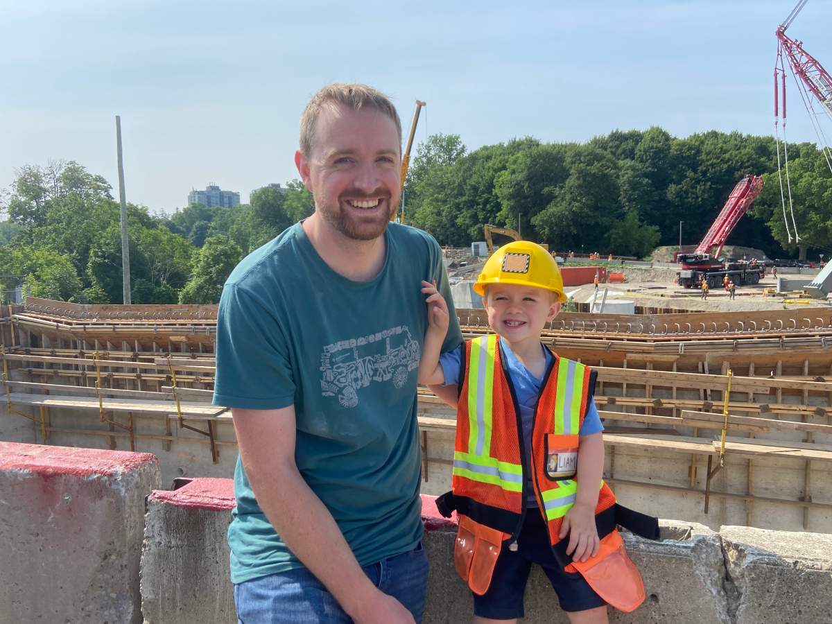 Liam Williamson (3), an aspiring construction worker, next to his father Matt Williamson on the site of the new Victoria Bridge in London, Ont., on Tuesday, June 20, 2023.