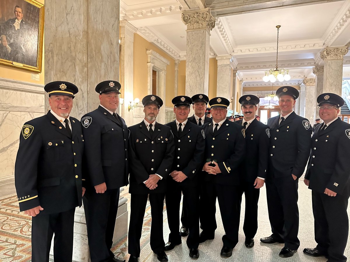 A group of firefighters standing in an ornate room.