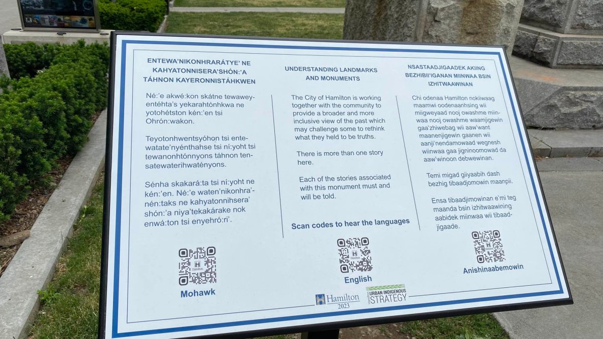 Photo of a sign at the foot of the Queen Victoria statue at Gore Park in Downtown Hamilton, Ont. The city says it has embarked on a "rethink" of monuments across the city some local Indigenous residents cite as a source of pain and harm.
