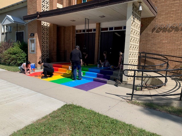 Ponoka residents repaint a rainbow display at Ponoka United Church after it was vandalized with tar and eggs, according to RCMP.