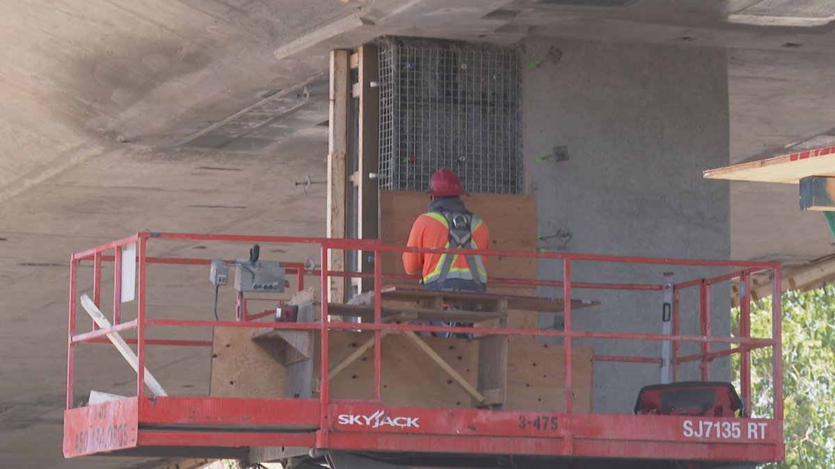 Worker conduct repairs on the overpass structure.