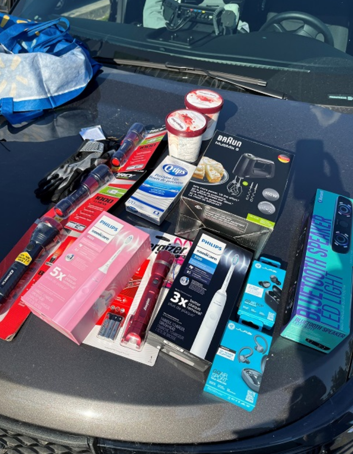 A portion of more than $5,000-worth of stolen goods is seen on the hood of a police vehicle after a one-day retail theft investigation blitz on May 25, 2023 in Surrey, B.C.