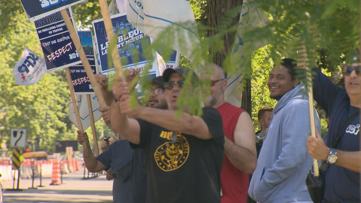Blue collar workers on strike outside Westmount's Victoria Hall. The city reached a tentative deal with workers on Friday. Union members vote on the deal Wednesday.