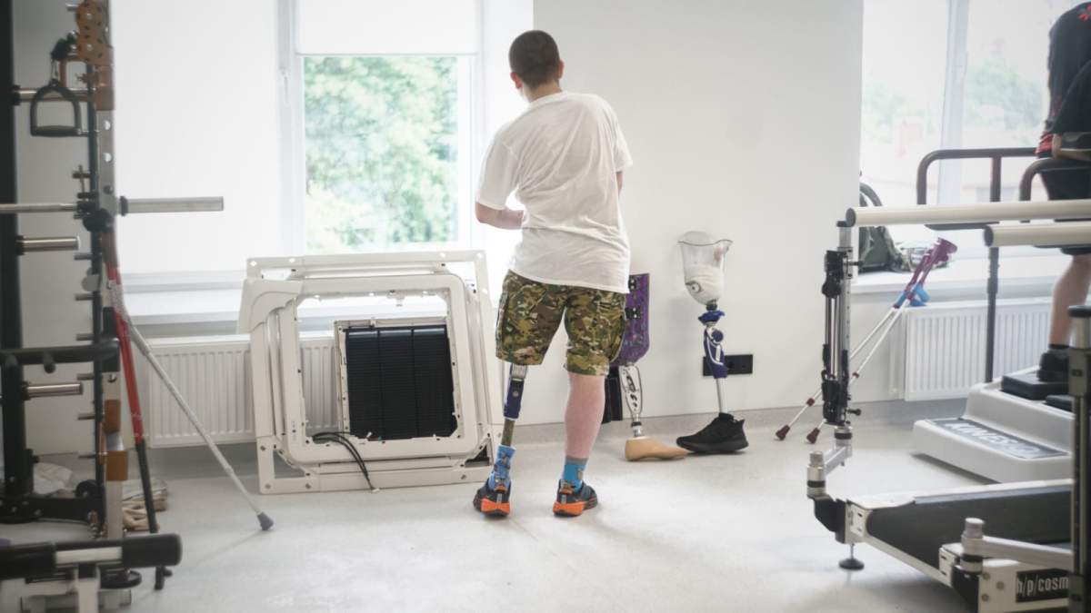A Ukrainian combat veteran stretches during exercises with his prosthetic limb.