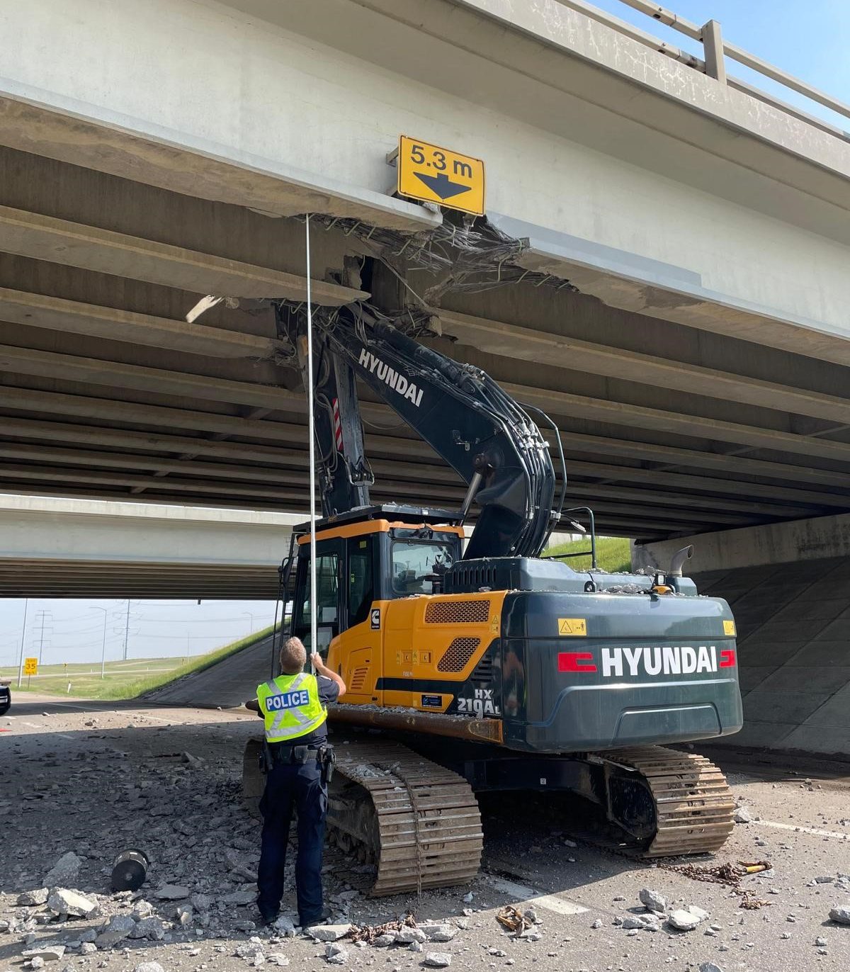 An excavator on a semi trailer collided with overpass bridge deck of Whitemud Drive at Anthony Henday Drive in southeast Edmonton on Friday, June 16, 2023.