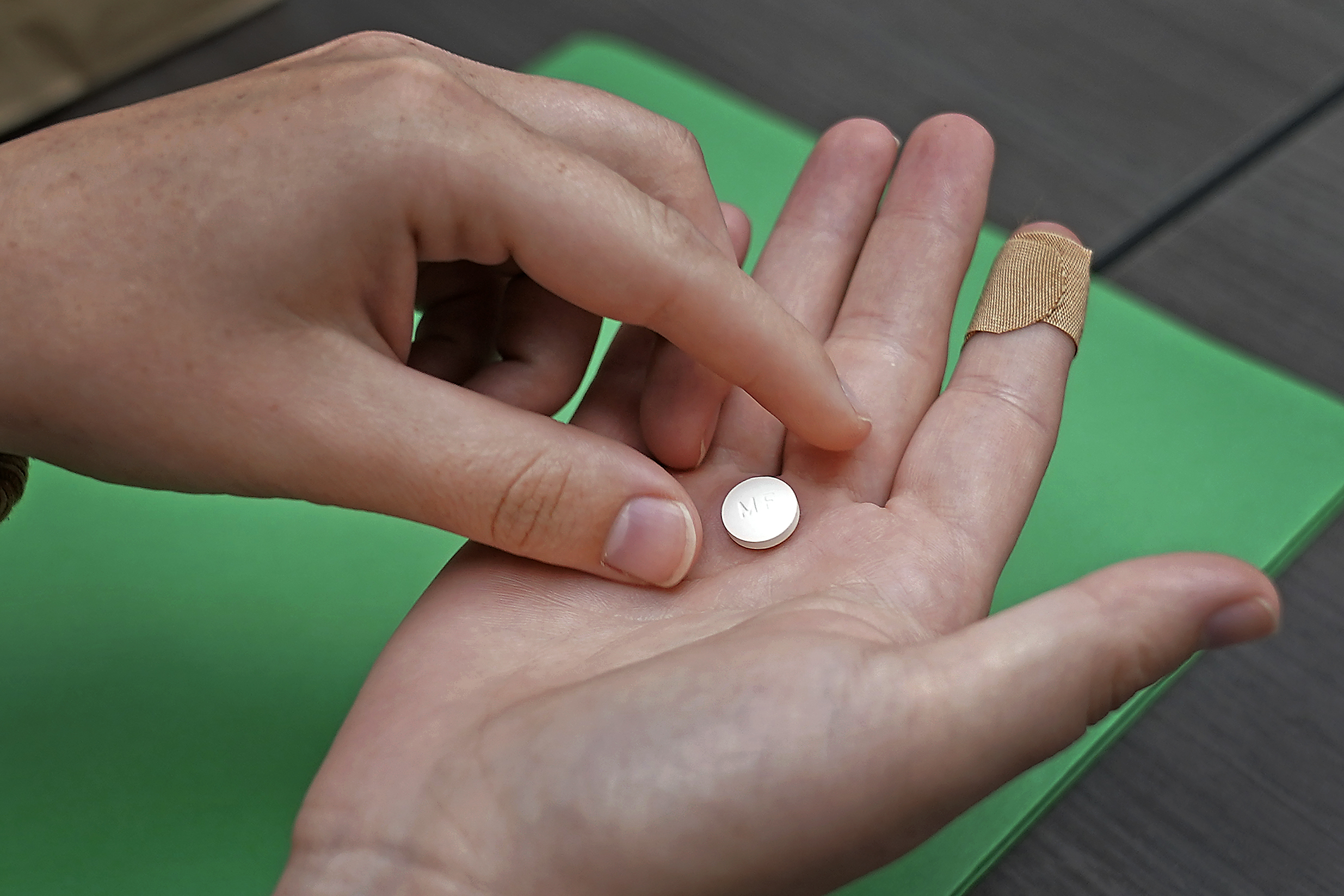 An abortion pill in a hand.