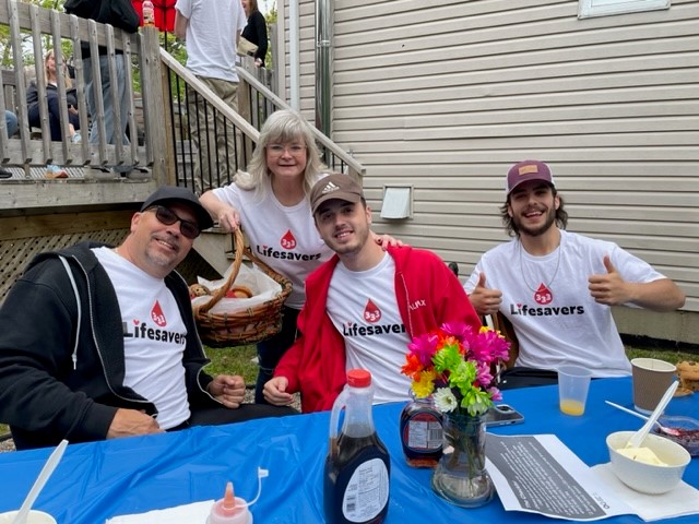 Organizer Patti Martin poses with a few of the students and parents before heading out to make their donations.