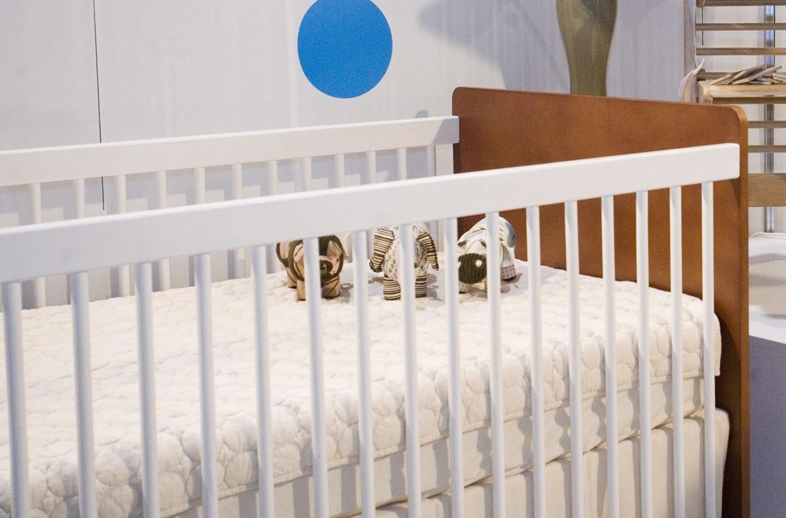 Close-up of a crib with stuffed animals inside.