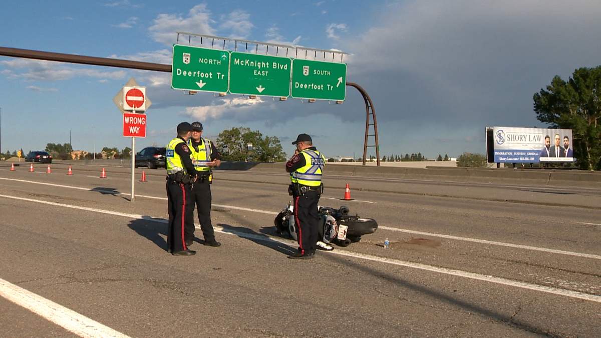 CPS members stand next to a damaged motorcycle following a June 23 crash on McKnight Boulevard N.E.