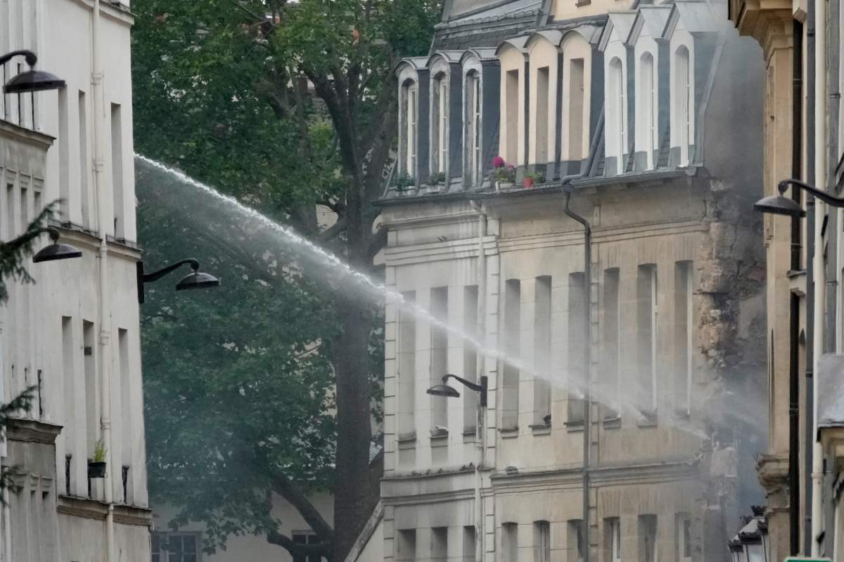 Firemen use a water canon as they fight a blaze Wednesday, June 21, 2023 in Paris. (AP Photo/Christophe Ena)