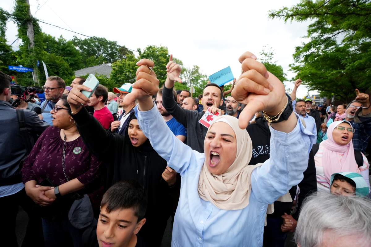 A woman gives thumbs down as she takes part in a protest against Pride in Ottawa.