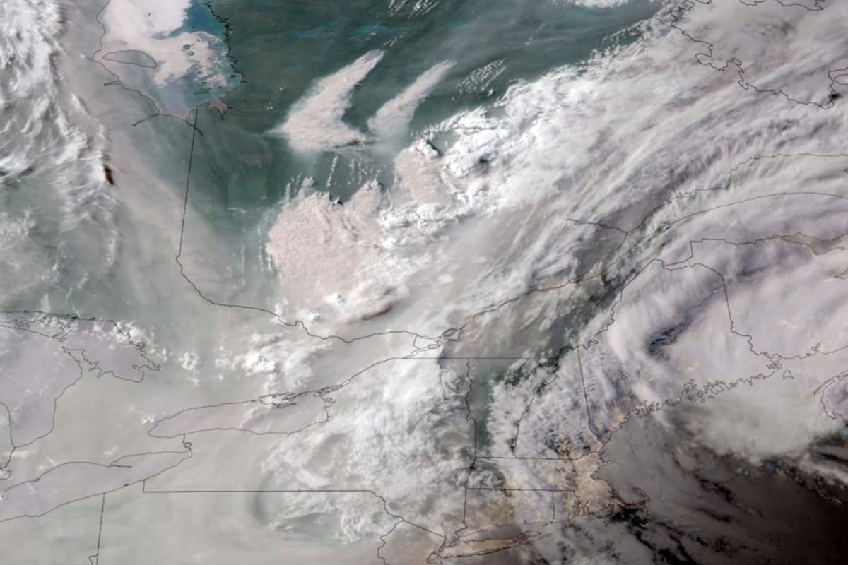 In this GOES-16 GeoColor satellite image taken Monday at 7 p.m. EDT and provided by CIRA/NOAA, smoke from wildfires burning in Quebec, top centre, drifts southward. (CIRA/NOAA via AP)