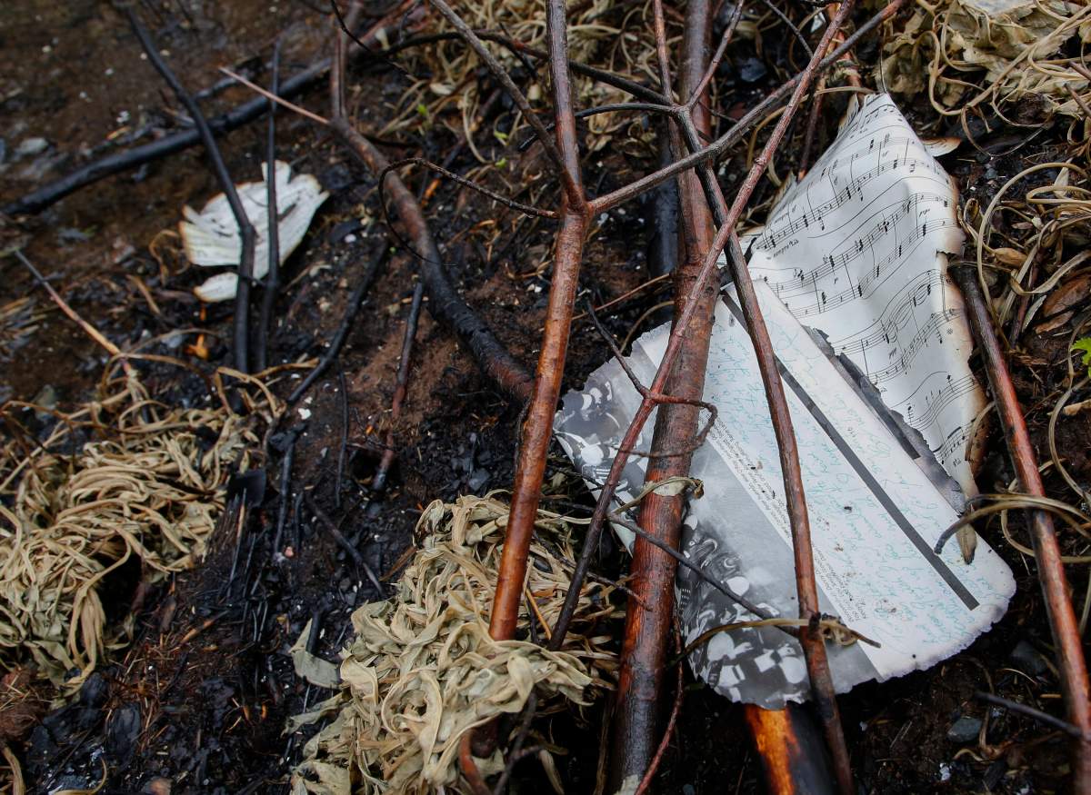 The burnt pages from a yearbook and a musical sheet, lie in a burnt ditch following last week’s wildfire on Carmel Crescent in Hammonds Plains, N.S. Tuesday June 6, 2023.