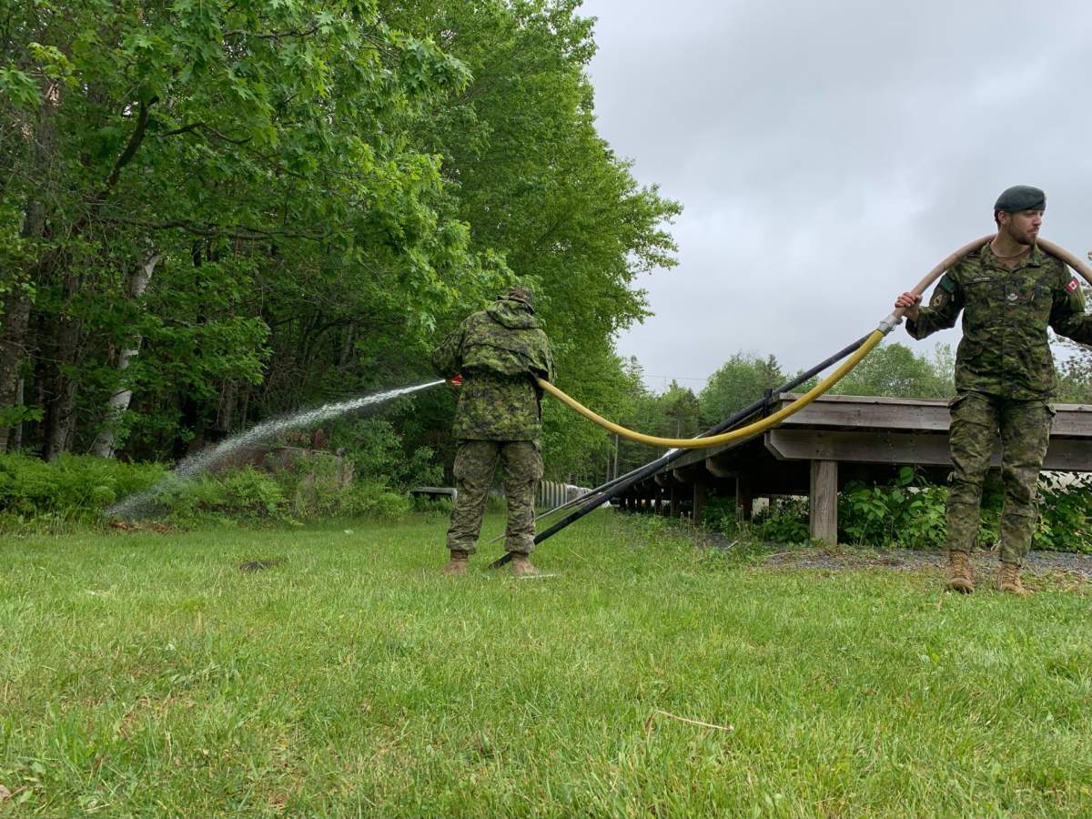 crews hold water hoses in Gagetown