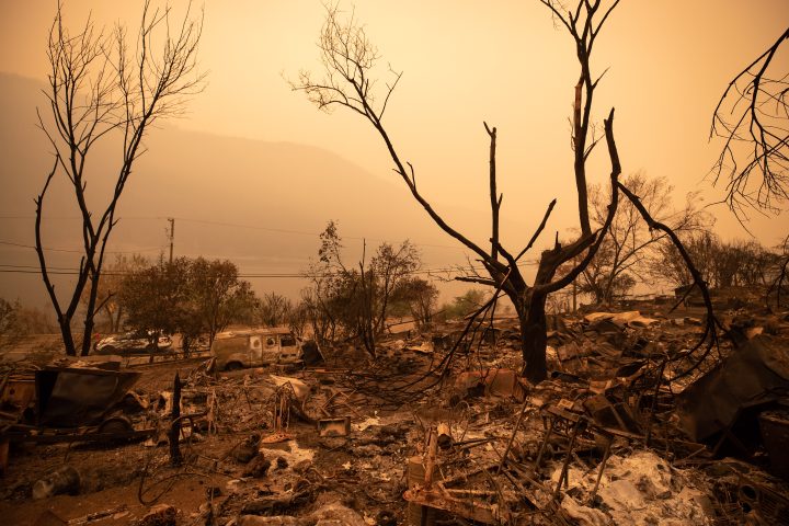 A property destroyed by wildfire in shown against a hazy yellow sky