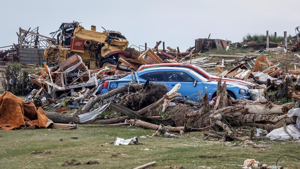 A preliminary report on a weekend tornado in central Alberta says winds were so violent they picked up a 10,000-kilogram farm combine and tossed it half the length of a football field. Vehicles sit amidst a home the tornado damage near Carstairs, Alta., Saturday, July 1, 2023. THE CANADIAN PRESS/Jeff McIntosh