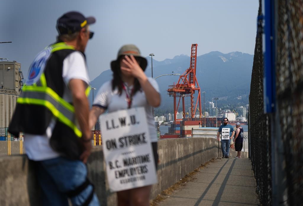 Striking International Longshore and Warehouse Union Canada workers picket at a port entrance in Vancouver, Tuesday, July 4, 2023.