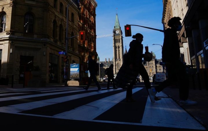 The Canada Flag flies on the Peace Tower of Parliament Hill as pedestrians make their way along Sparks Street Mall in Ottawa on Tuesday, Nov. 9, 2021. Ottawa's city council has greenlit a plan to create a mental-health emergency dispatch line and a mobile crisis response team that would be in operation 24/7. 