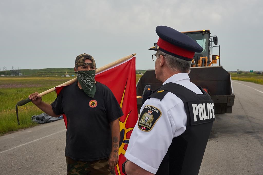 A protester speaks with Winnipeg Police Inspector Gord Spado, as city of Winnipeg workers remove the blockade on the main road into the Brady Road landfill just outside of Winnipeg Tuesday July 18, 2023. 
