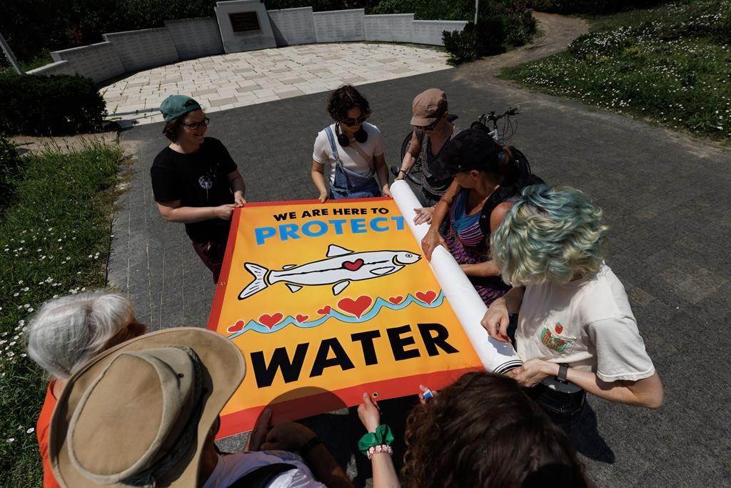 Protestors roll up a banner following a rally to raise concerns and opposition to the Ontario provincial government's plans to expand mining operations in the so-called Ring of Fire region in Northern Ontario, in Toronto, Thursday, July 20, 2023. THE CANADIAN PRESS/Cole Burston.