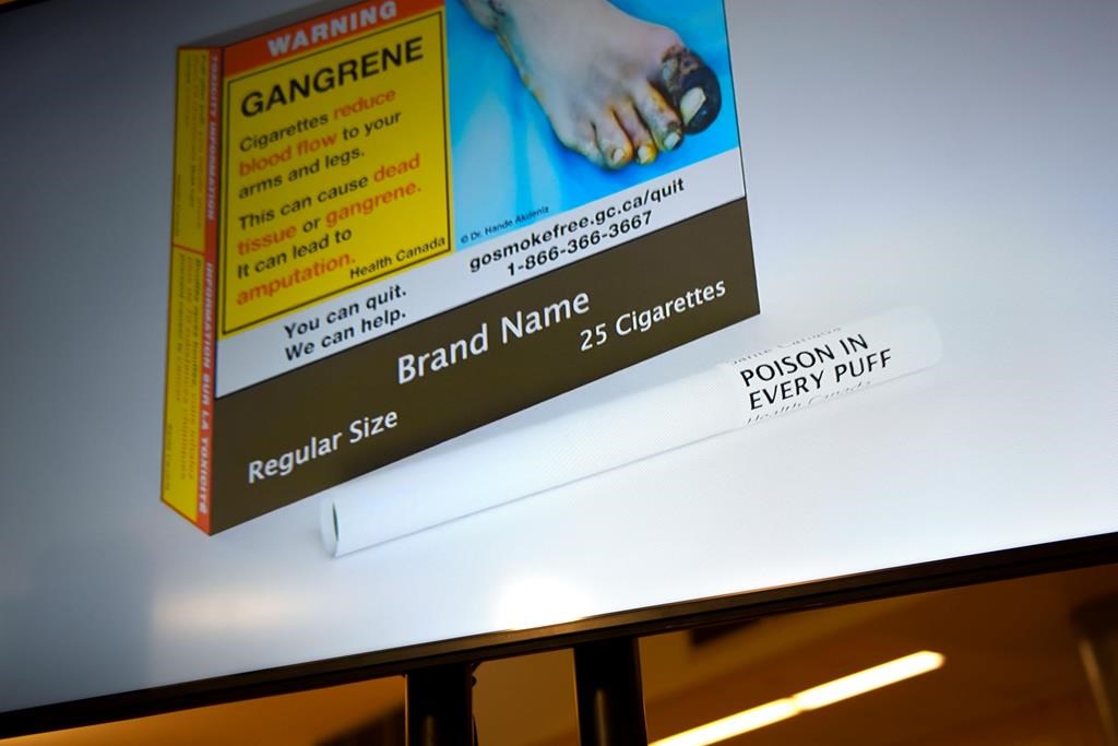 New Health Canada regulations that require warning labels to be printed on individual cigarettes are coming into effect Tuesday. An example of cigarette packaging with expanded warnings, including a warning printed on the cigarettes themselves, is shown on a screen after a news conference, in Ottawa, Friday, June 10, 2022.