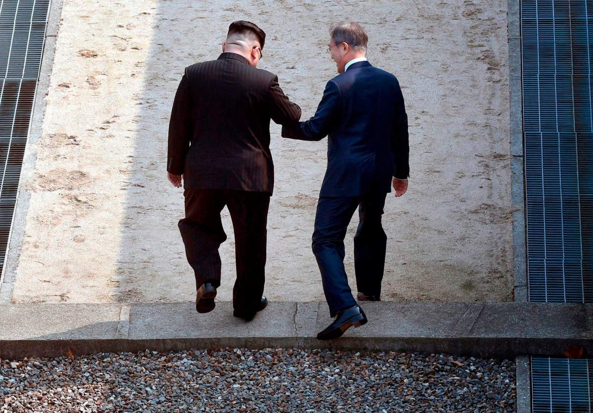 North Korean leader Kim Jong Un, left, and South Korean President Moon Jae-in cross the military demarcation line at the border village of Panmunjom in Demilitarized Zone Friday, April 27, 2018.