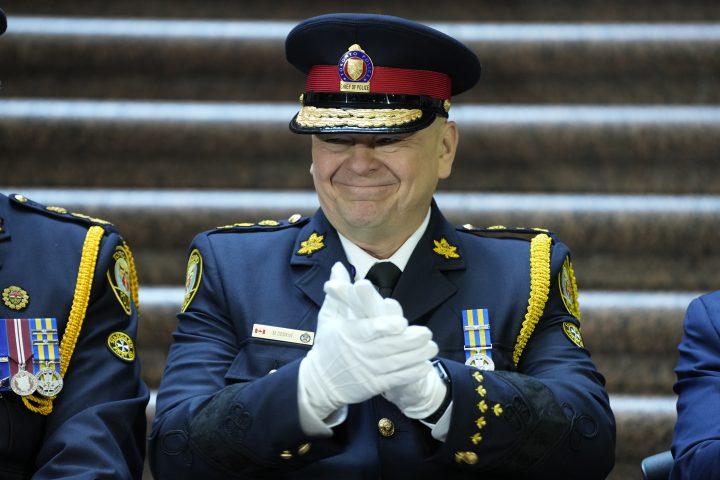 Incoming Toronto Police Chief Myron Demkiw claps and smiles at members of his family during a police change of command ceremony in Toronto, Monday, Dec.19, 2022.