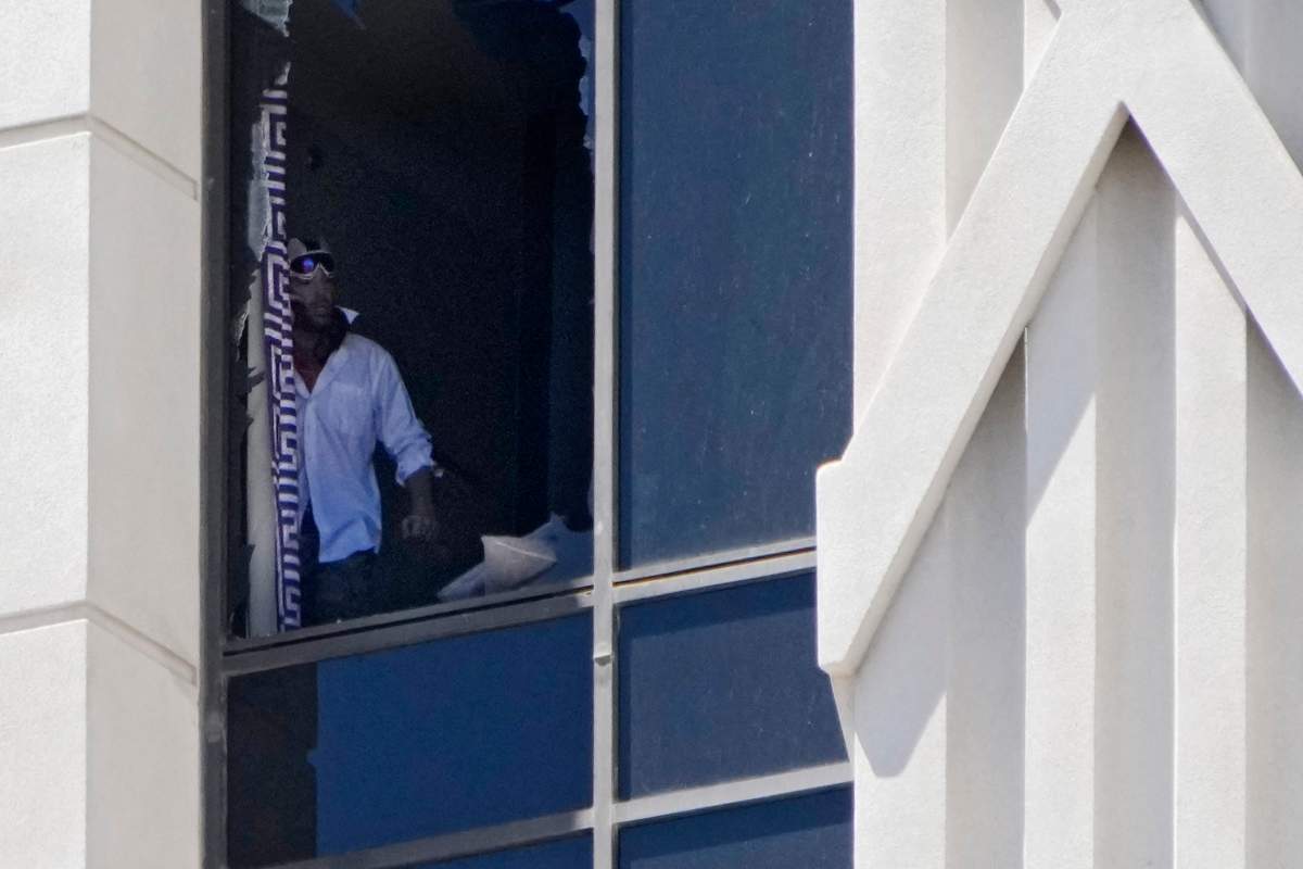 A person looks out a broken window on a hotel tower at Caesars Palace hotel-casino, Tuesday, July 11, 2023, in Las Vegas.