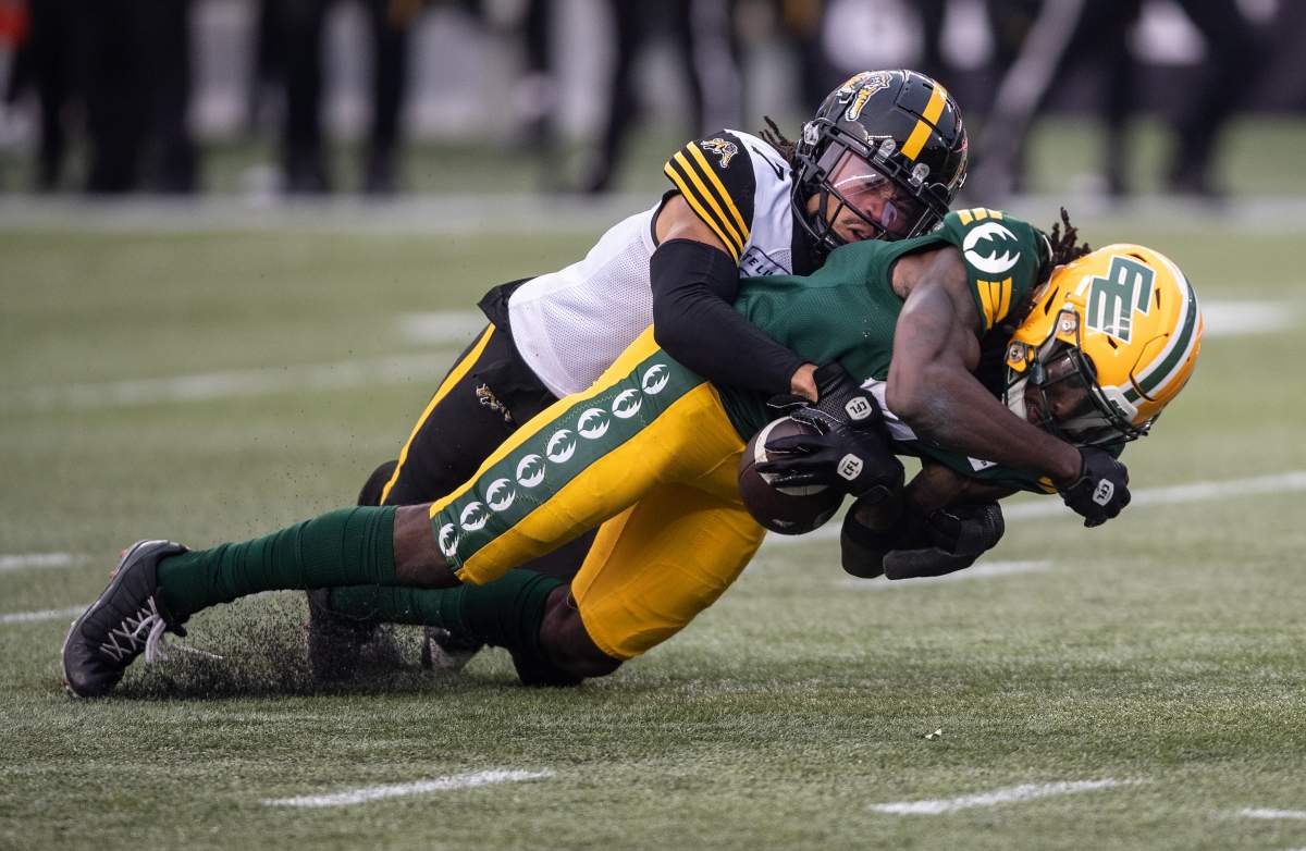 Hamilton Tiger-Cats' Javien Elliott (7) tackles Edmonton Elks' Steven Dunbar Jr.  (7) during second half CFL action in Edmonton, Alta., on Thursday July 13, 2023.