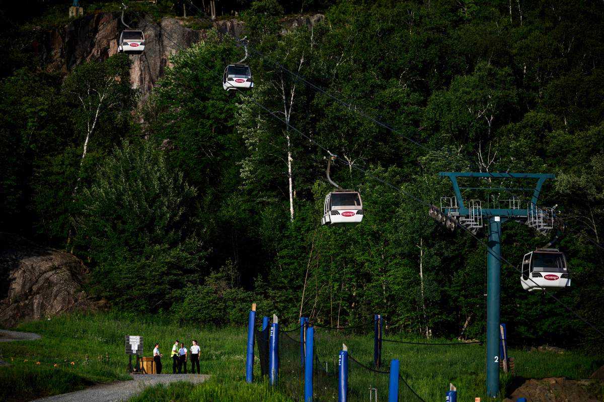 Cadets from the Sureté du Québec stand near the base of a chairlift where one person died and another remains critically injured after a gondola crashed into a piece of construction equipment at Mont-Tremblant Resort in Mont-Tremblant, Que., on Sunday, July 16, 2023.
