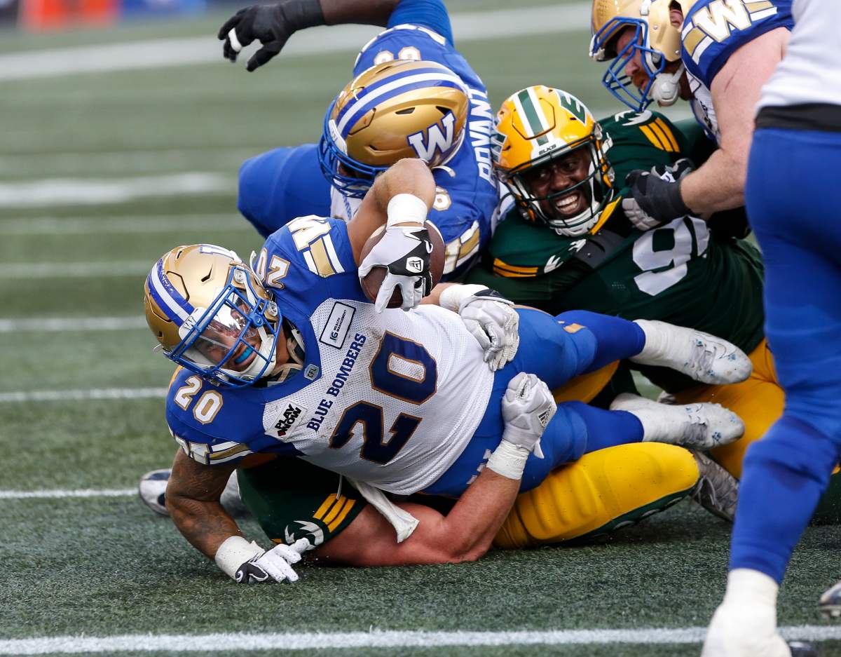 The Winnipeg Blue Bombers’ Brady Oliveira (20) reaches out for the end zone but is short of the touchdown against the Edmonton Elks during first-half CFL action in Winnipeg Thursday, July 20, 2023.