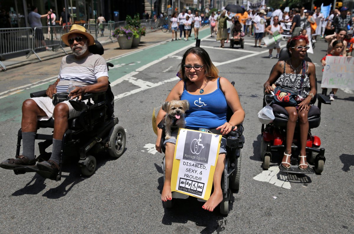 Jessica Delarosa, center, and her dog Mayim participate in the inaugural Disability Pride Parade, Sunday, July 12, 2015, in New York.