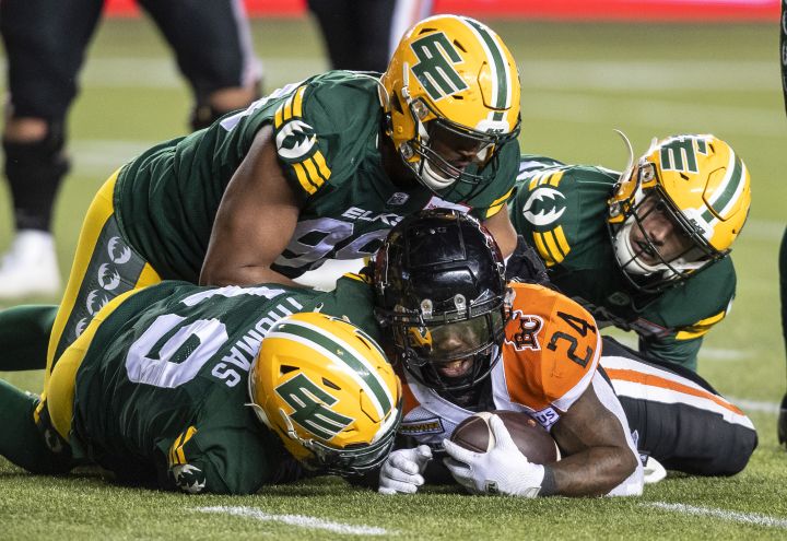 B.C. Lions' James Butler (24) is tackled by the Edmonton Elks during first half CFL action in Edmonton, Alta., on Friday October 21, 2022.