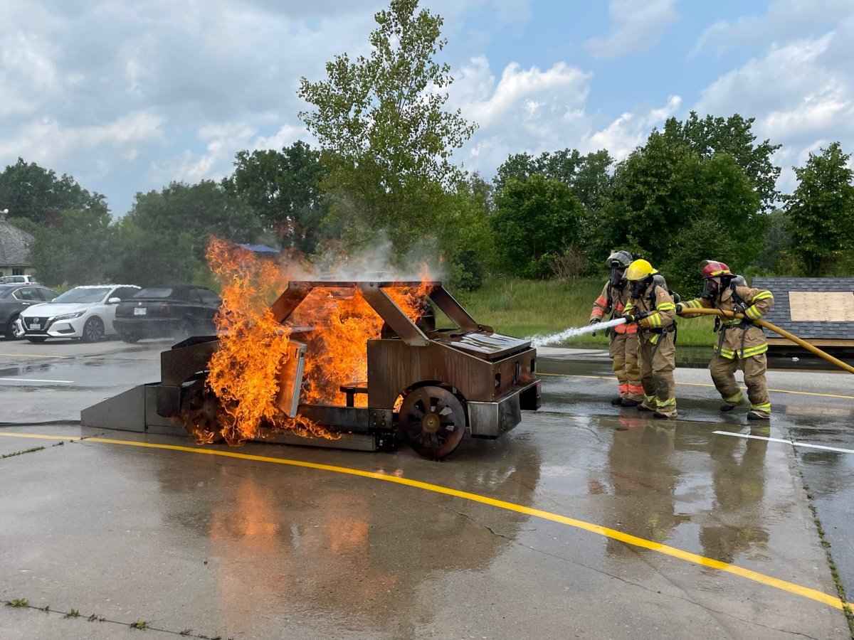 Camp Future Firefighters in Training participants Grace Cullen and Grace Carter work to suppress a simulated car fire at Fire Station 9 on July 20, 2023.