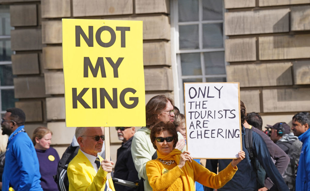 Anti-monarchy protesters hold up placards as they gather near St Giles' Cathedral ahead of a National Service of Thanksgiving and Dedication, in Edinburgh on July 5, 2023. Scotland on Wednesday will mark the Coronation of King Charles III and Queen Camilla during a National Service of Thanksgiving and Dedication where the The King will be presented with the Honours of Scotland.