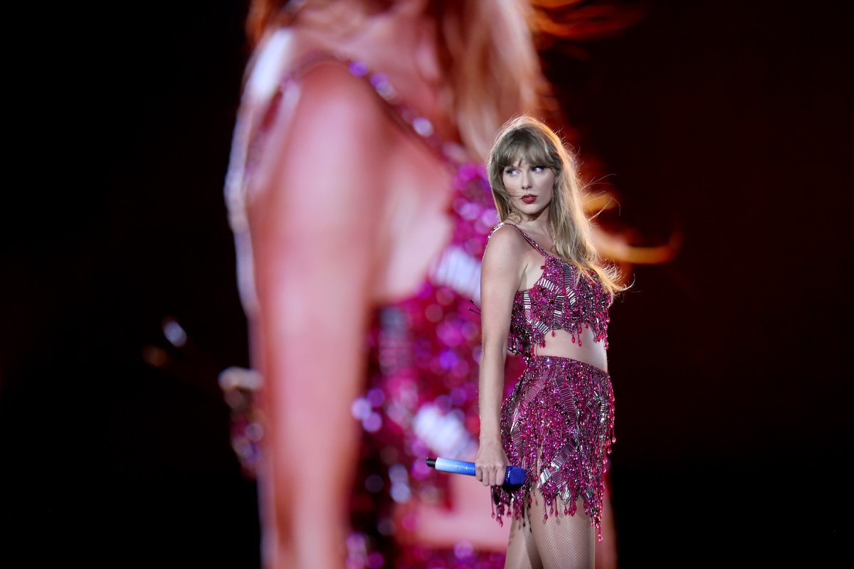 Taylor Swift on stage. She is wearing a sparkly, pink beaded two-piece set.