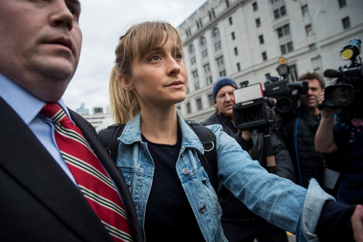 Allison Mack in a denim jacket outside a courthouse.