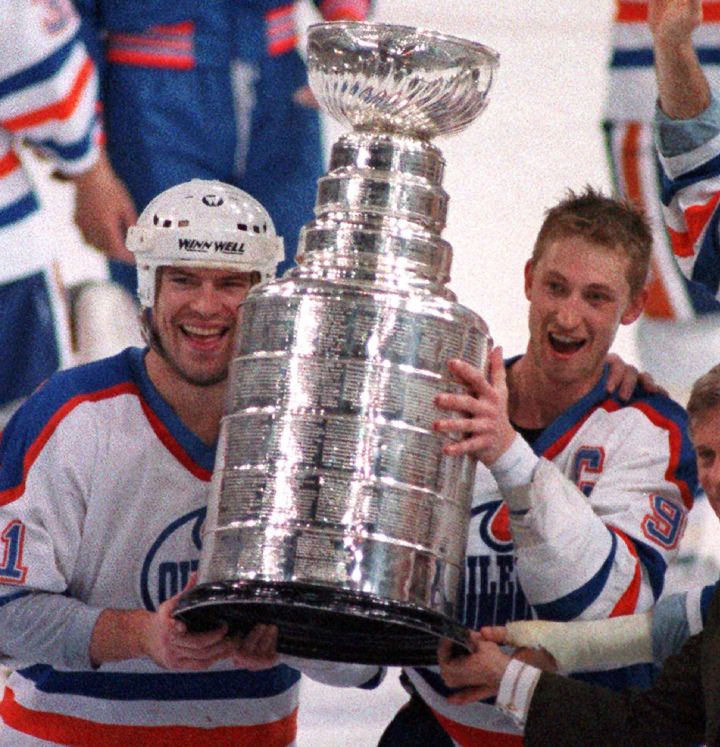 Edmonton Oilers' Wayne Gretzky, right, and Mark Messier hold up the Stanley Cup trophy, May 26, 1988 following their 6-3 win over the Boston Bruins in the Stanley Cup Finals in Edmonton.