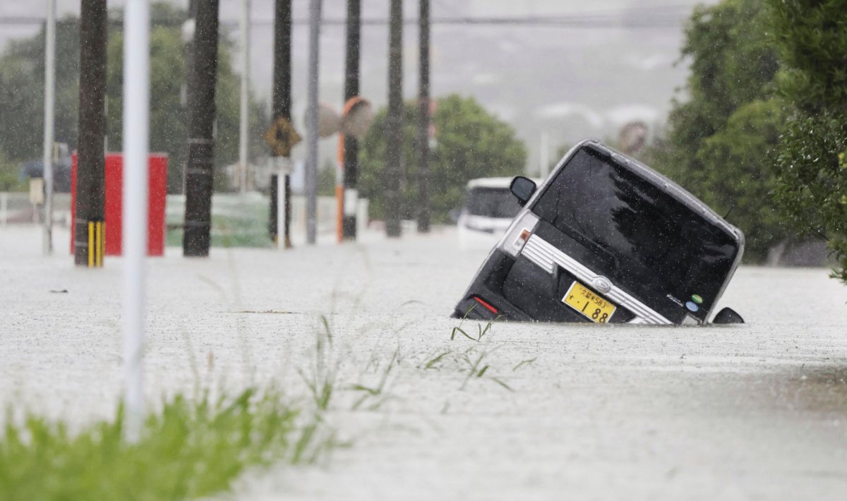 A vehicle is stuck on a street flooded due to a heavy rain